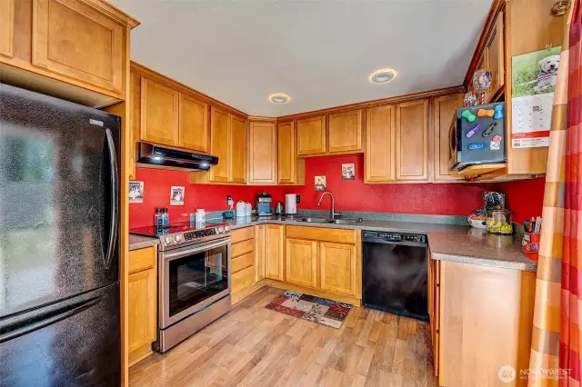 Kitchen with Corian counters, newer stove and lots of cabinets.