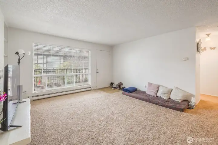 Front room with large windows, plenty of natural light. New carpet.