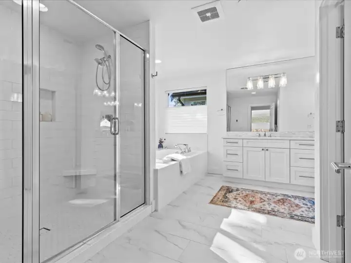 A true spa-inspired bath featuring heated tile floors, a dual head shower with tile surround, double vanities and a large soaking tub!
