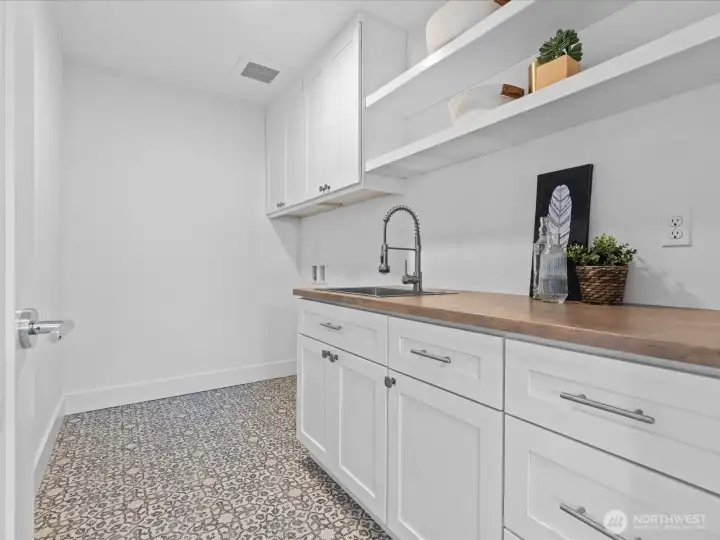Spacious utility room offers plenty of built-in storage, in addition to the linen closet (not pictured)