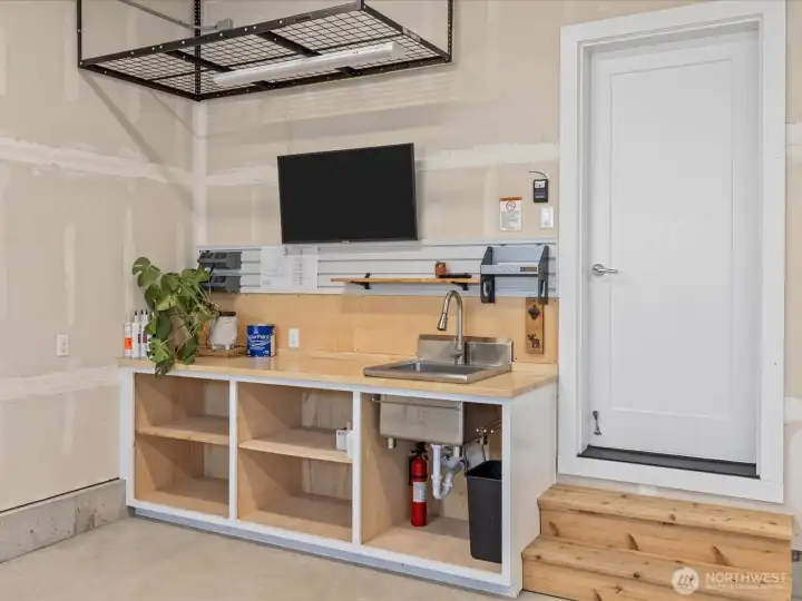 Built-in workbench, utility sink and overhead storage within the garage