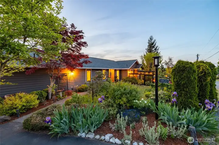 The charming front walk and curves along the home to the front door, while planting beds offer color and privacy from the road.