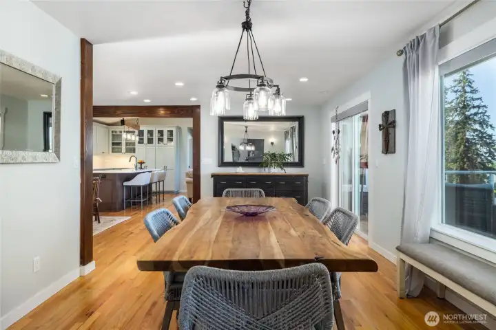Real oak floors gleam throughout the kitchen and multiple dining areas, including here in the dining room, where those stunning water views are on display through the large picture window.