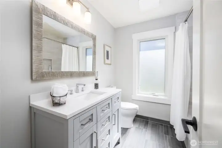 Main floor full bath has been completely renovated to include tile floors and surround, new vanity with quartz counter, and all new fixtures.