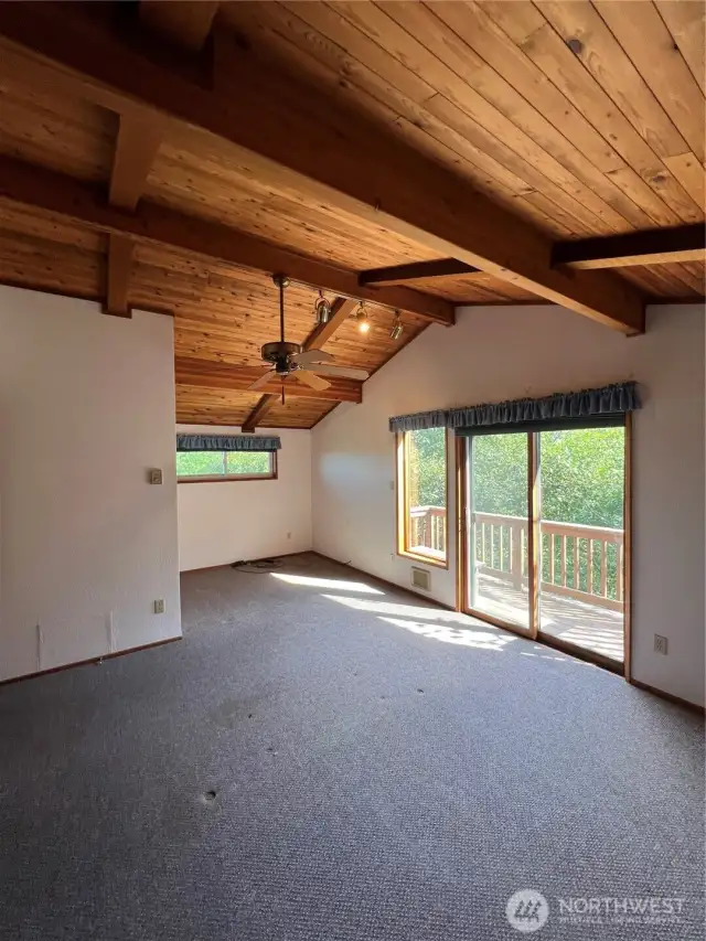 Primary Bedroom also has ceiling fan and sliding glass doors out to the private deck.