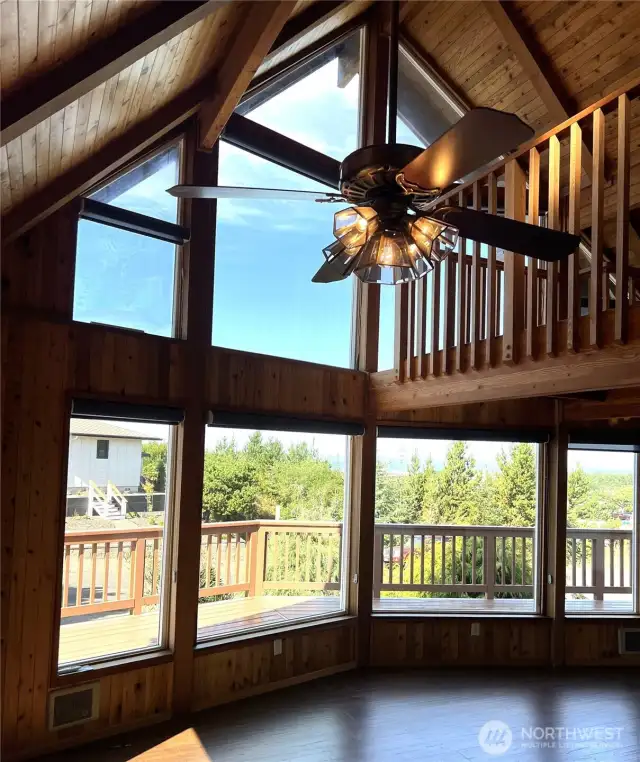 High cathedral wood ceilings give a warm welcoming feel. Ceiling fan and light keep the room comfortable. Remote controlled shades are installed.
