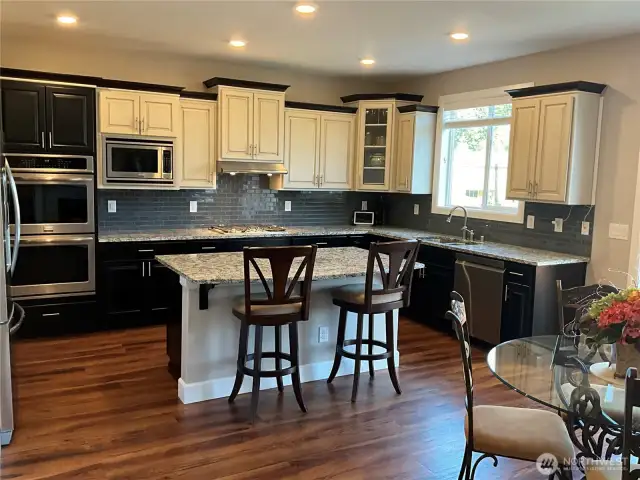 Chef's Kitchen with custom cabinetry, 5-burner gas stove, slab granite counters & double ovens
