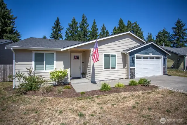 Welcoming covered entry aggregate porch,sidewalk and driveway