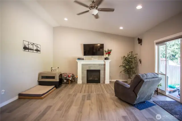 view from kitchen, gas log fireplace with custom surround/mantle, area to run cords and wires to keep them out of sight