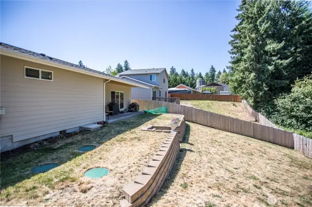 Aggregate back patio, terraced landscaping completely fenced with gates