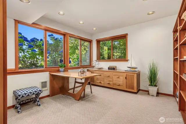 Downstairs office has beautiful built-in shelving and a custom wood desk and storage area.