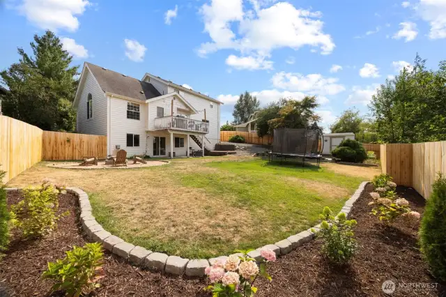The backyard is fully fenced in, with a stunning firepit area, refreshed landscaping and storage shed.