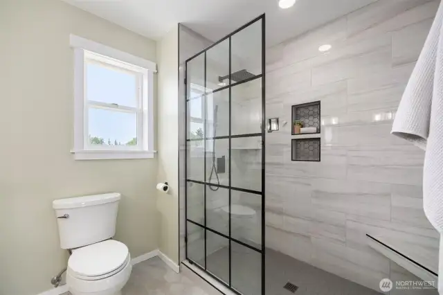 The walk in tile shower is spa-inspired, spacious, and filled with light.