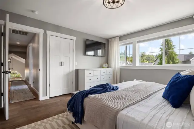 The oversized primary bedroom, with beautiful windows, a closet and ensuite bathroom.