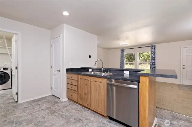 Kitchen peninsula is perfectly placed between both living areas