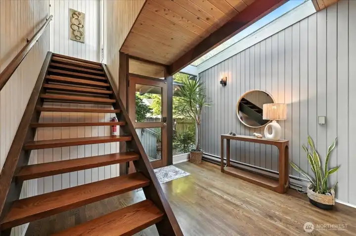 Sunlit stairwell leads to the coastal-inspired primary bedroom. where sweeping ocean views and soft sea breezes await.