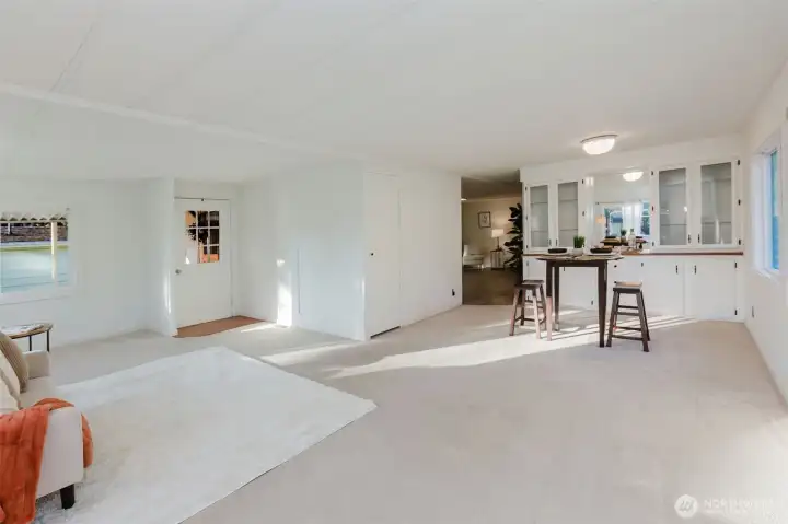 Spacious open-concept living and dining area with large windows.