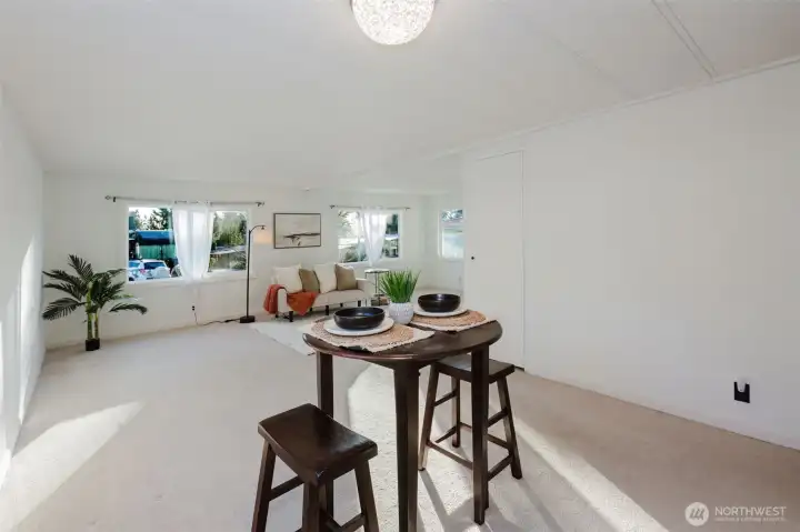 Expansive living area showcasing the flow between entry, living, and dining spaces, offering versatility for various furniture arrangements.