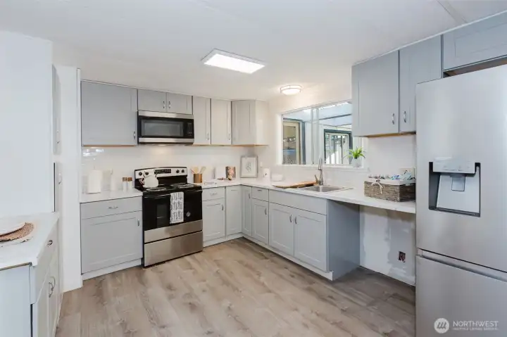 Spacious kitchen with ample counter space, storage, and natural light, opening into an additional living or flex area.