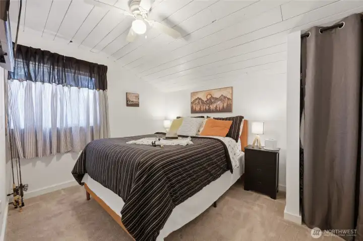 Front bedroom with attached TV and small closet, carpeted floor, nice clean paint.  Peaceful!