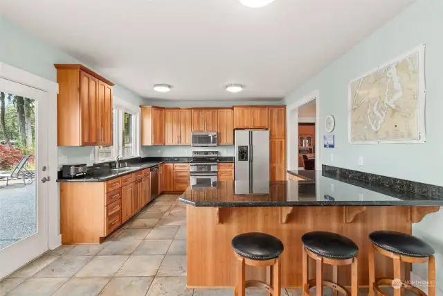 Handsome and well appointed kitchen. Lovely granite countertops, custom cabinetry and breakfast bar.