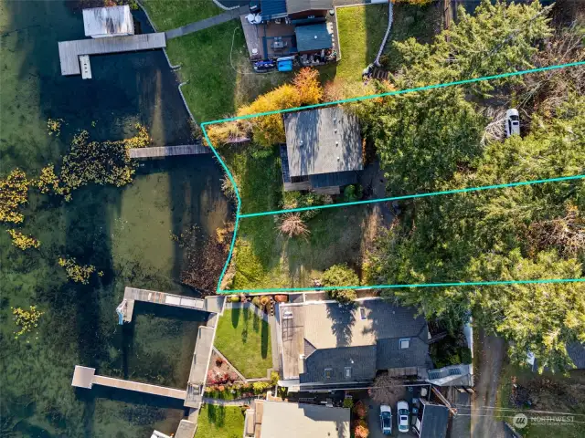 Aerial view of cabin, dock, two side by side waterfront lots.