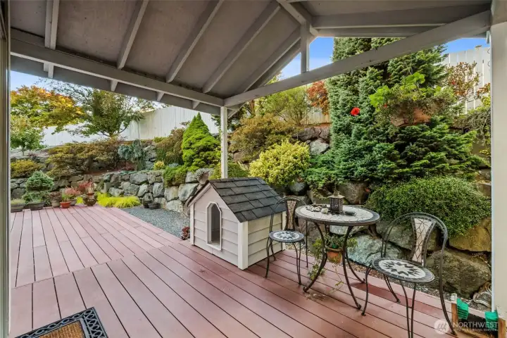 Back yard covered deck expands to side yard off lower level family room.