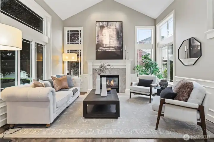 Soaring ceilings and an open ambiance create a sense of grandeur, while expansive windows frame lush outdoor views. Whether hosting intimate gatherings or savoring a quiet moment with a book, this space offers the perfect blend of elegance and comfort.