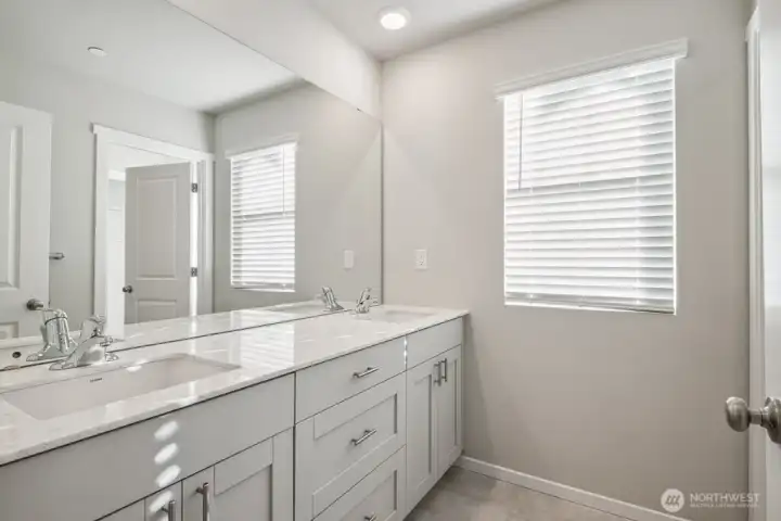 Primary bathroom offers double vanity with quartz countertops and soft close doors. Photo is representational. Actual home is under construction and colors, materials, and finishes may vary. See site agent for details.