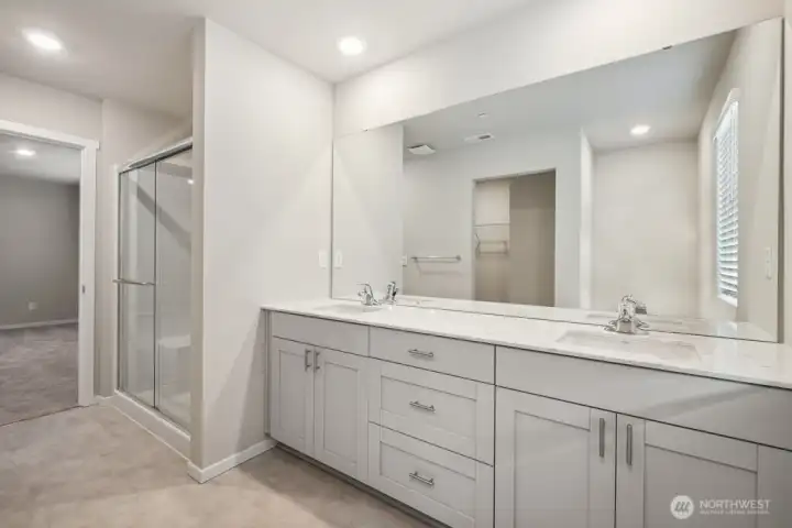 Primary bathroom features double vanity and step in shower. Photo is representational. Actual home is under construction and colors, materials, and finishes may vary. See site agent for details.