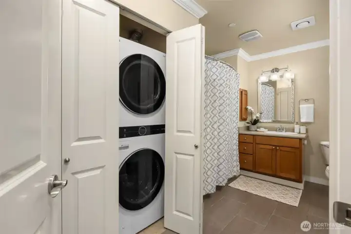 Full-sized stacked washer dryer inside the spacious bathroom.