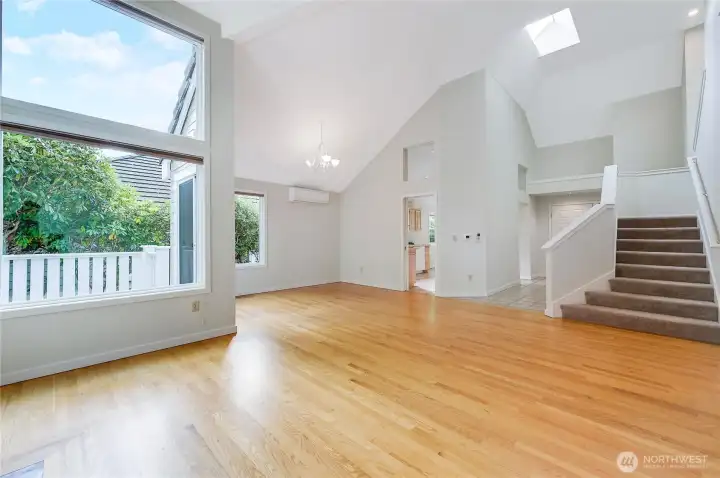 From the living room, looking into the dining area, note the mini-ductless split that both heats and cools the condo. Stairs on the right lead to the open loft area and the private guest bedroom ensuite.