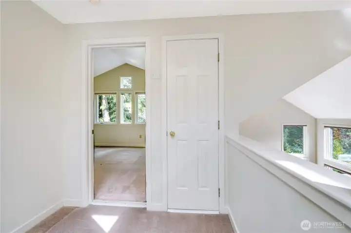 From the loft looking into the guest bedroom.  A closet on the right provides storage space. Angled, vaulted ceilings create an interesting bright space throughout the condo.