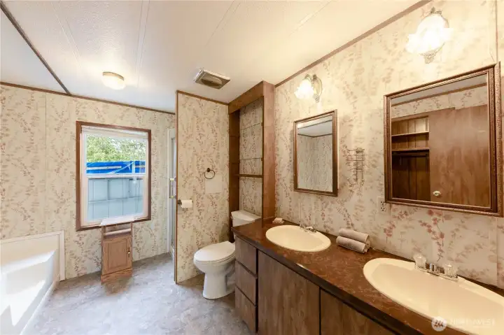 The spacious primary bathroom has double vanities and a soaking tub.