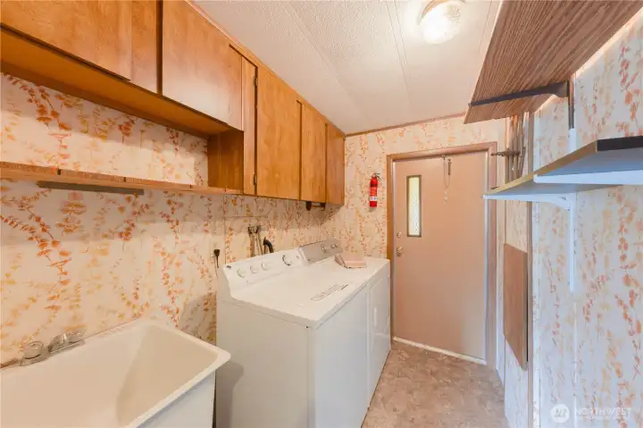 The laundry room/ mud room has a back door and large utility sink.