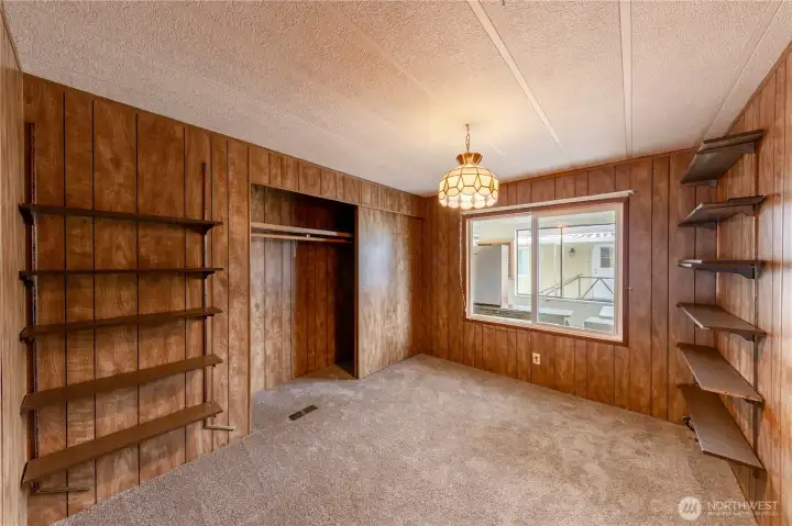 This bedroom has a large window that looks into the enclosed sunroom.