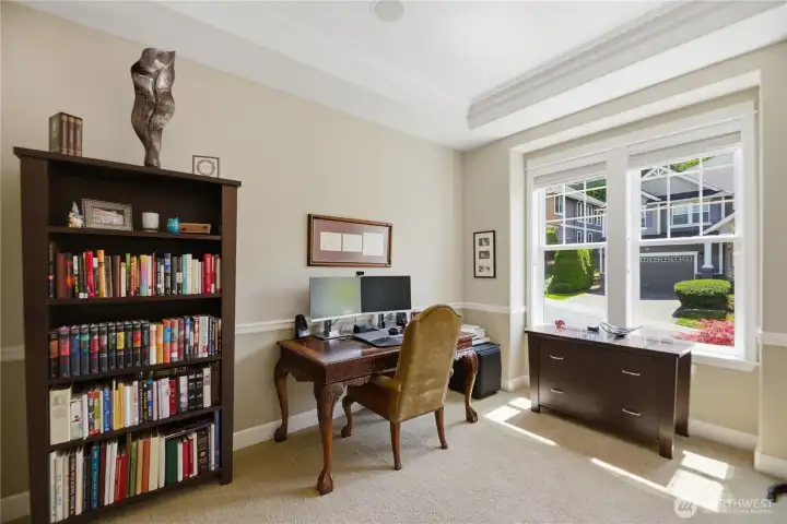 Spacious executive office featuring a coved ceiling, crown molding, chair rail accents, and glass French doors.