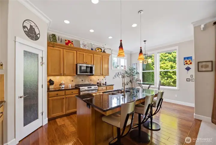 Rich hardwood flooring, slab granite countertops, pull-out cabinetry shelving, and stainless-steel appliances enhance both beauty and functionality.