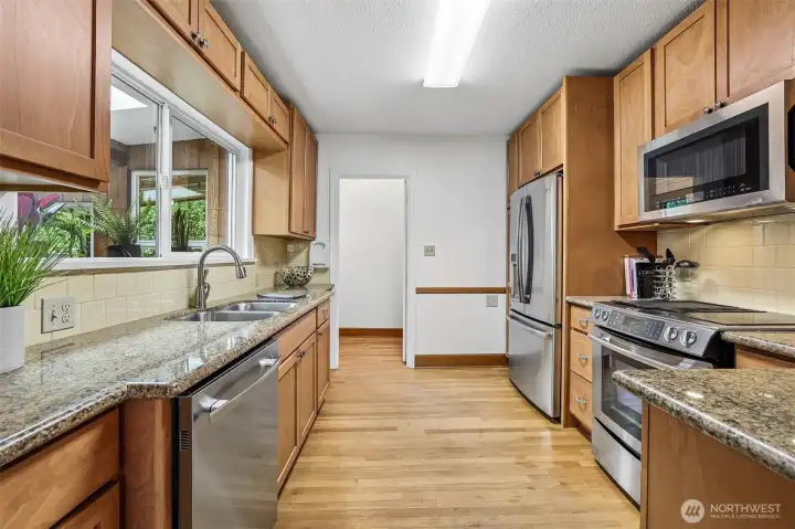 This kitchen has been updated but flows seamlessly with the rest of the home. Granite counters, full height tile backsplash, stainless steel appliances, hardwood floors & beautiful cabinetry-functional & lovely.