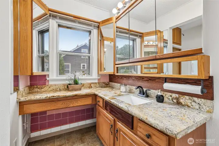 Adjacent to the primary bedroom is this spacious bathroom with granite counters & tile floors.