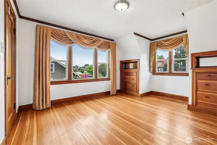 One of the upstairs bedrooms. So much charm with the built-in dressers & wood wrapped windows