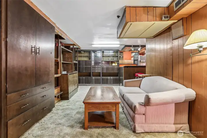 More of the basement with built-in storage & around the corner is a large bar