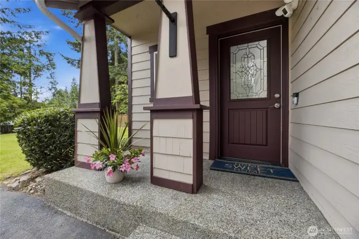 A charming front porch and covered entry, complete with a quaint sitting area that offers a warm welcome home.