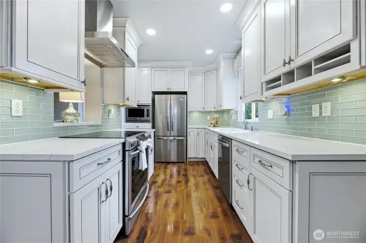 Bright kitchen showcasing quartz countertops, premium KraftMaid cabinetry with under-cabinet lighting, and elegant crown molding.