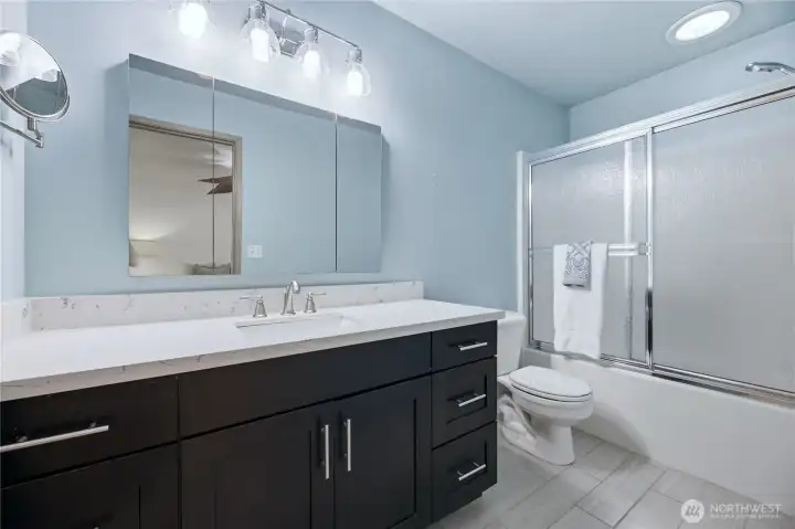 Primary bathroom featuring a generous layout and an energy-efficient solar tube skylight above the shower/tub combo.