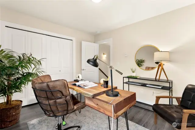 This second bedroom (currently staged as an office) and  has hardwoods plus spacious closet.
