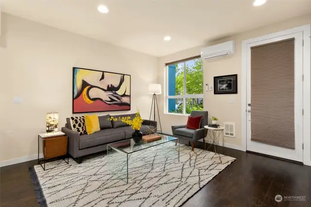 Open style living with hardwood floors, Ductless Mini-Split for A/C, kitchen island with seating, quartz countertops, stainless appliances plus an abundance of cabinets.