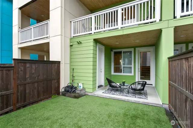 Lower back yard patio and turf lawn, and storage unit.