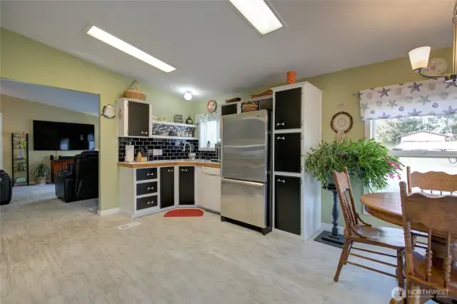 Kitchen is spacious with vaulted ceilings, sky lights, and plenty of natural light from the windows and door.  Next, we head back to the living room and into the primary suite.