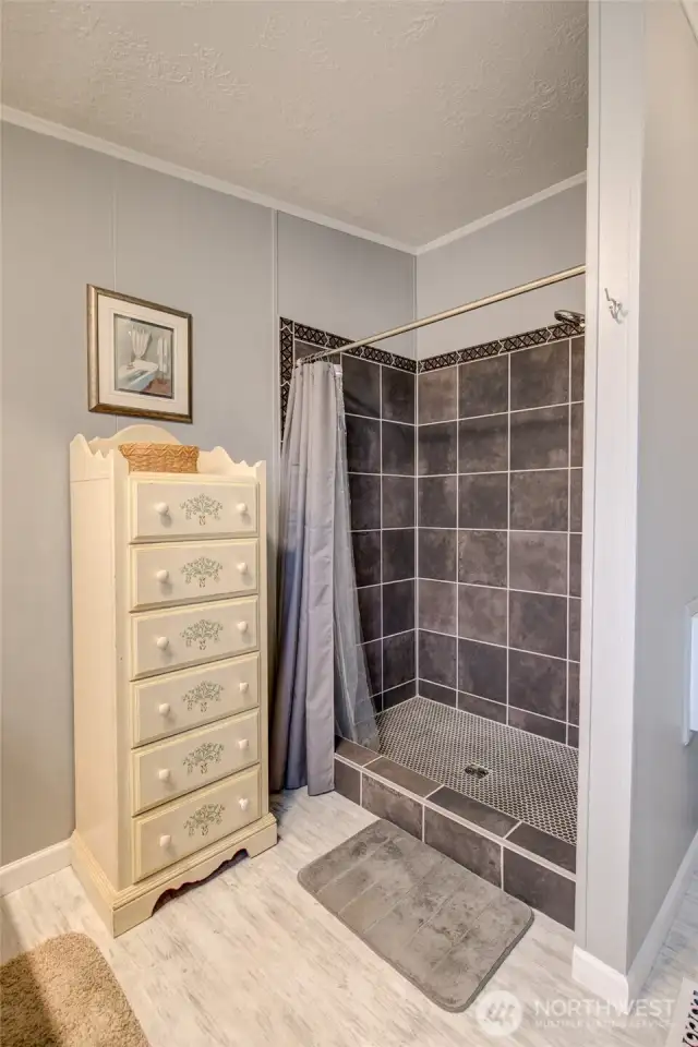 Nicely tiled, step-in shower in primary bathroom.